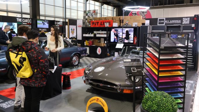 Fiera di auto classiche con auto vintage e espositori di accessori automobilistici.