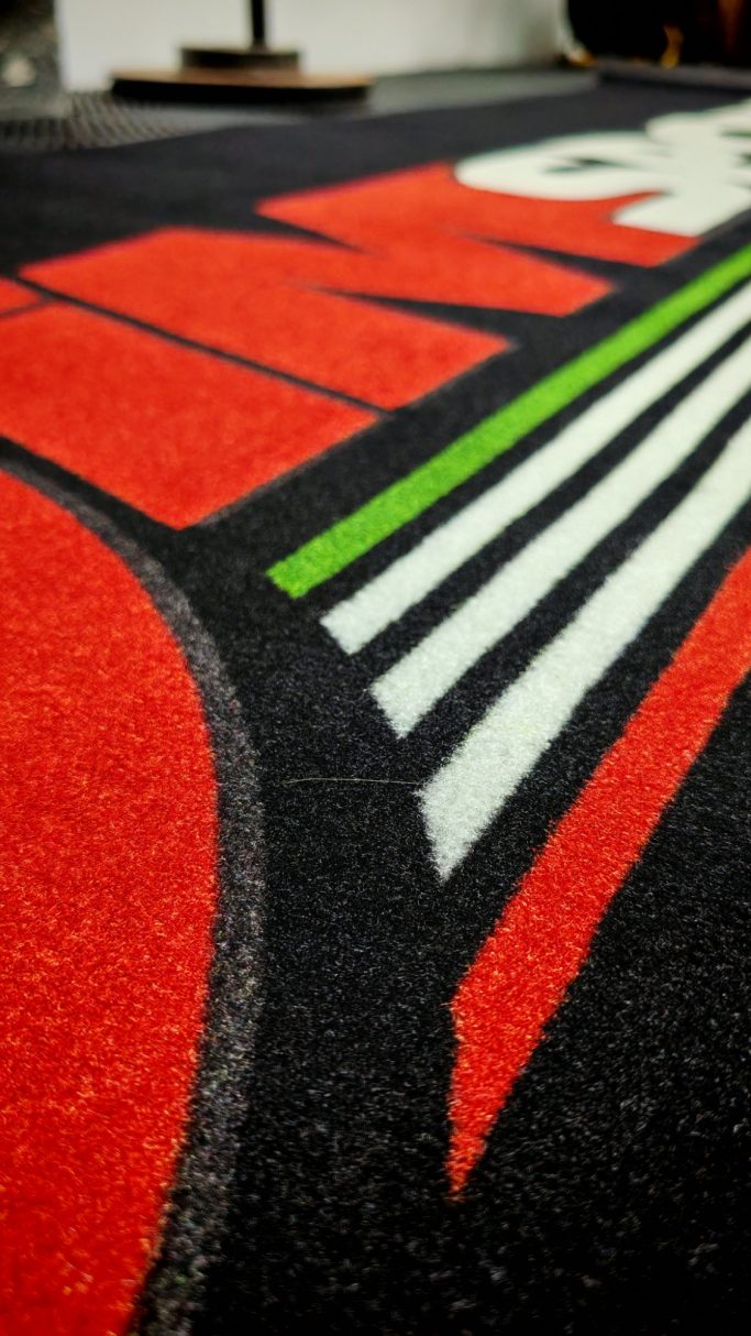 Texture and colors of a black surface with red, green, and white graphic design elements.
