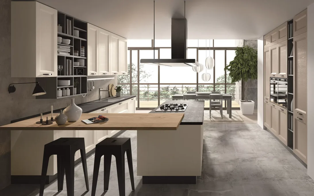 Cucina moderna con isola centrale, arredi chiari e grandi finestre che offrono luce naturale.