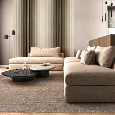 Salotto moderno con divano beige, tavolino rotondo e pareti a strisce.