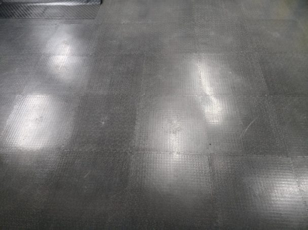 Black floor with a glossy finish and visible light reflections.