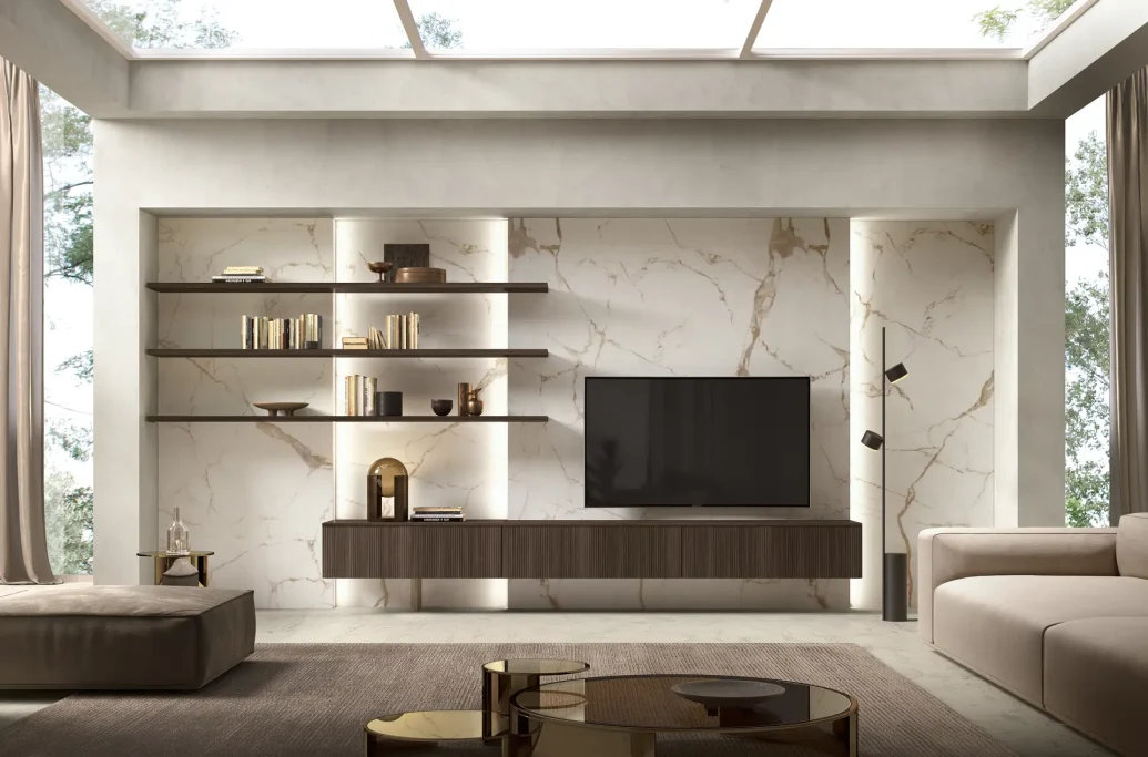 Modern living room with a TV, shelves, and neutral decor. Bright natural light from a skylight.