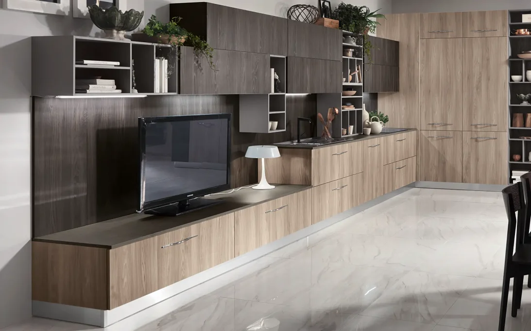 Modern kitchen with wooden cabinets, a TV, and a sleek countertop.