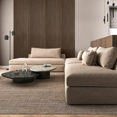 Moderna zona giorno con divano beige, tavolino rotondo e parete in legno.