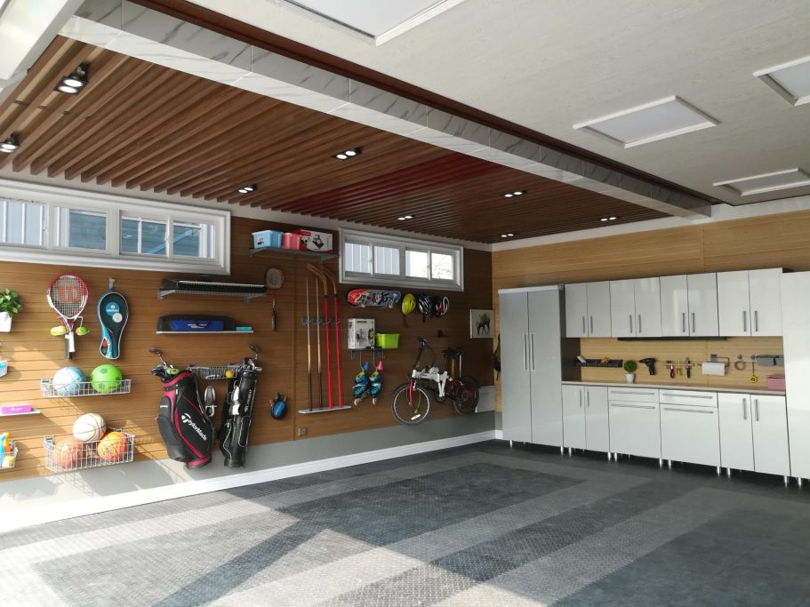 Garage interior featuring organized sports equipment and cabinetry.