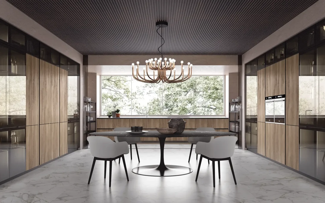 Cucina moderna in legno e vetro con tavolo centrale e lampadario elegante.