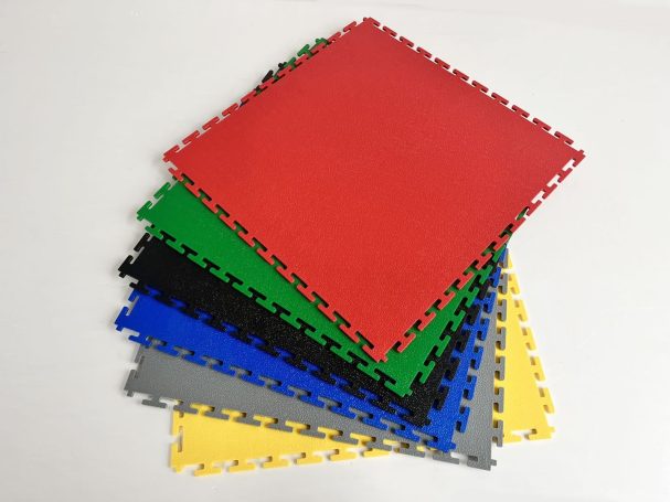 Pannelli di gomma colorati impilati, in rosso, verde, nero, blu, grigio e giallo.